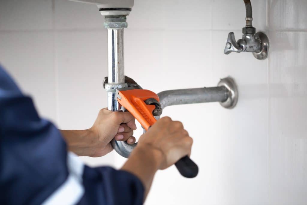 Plumber at work in a bathroom, plumbing repair service, assemble and install concept