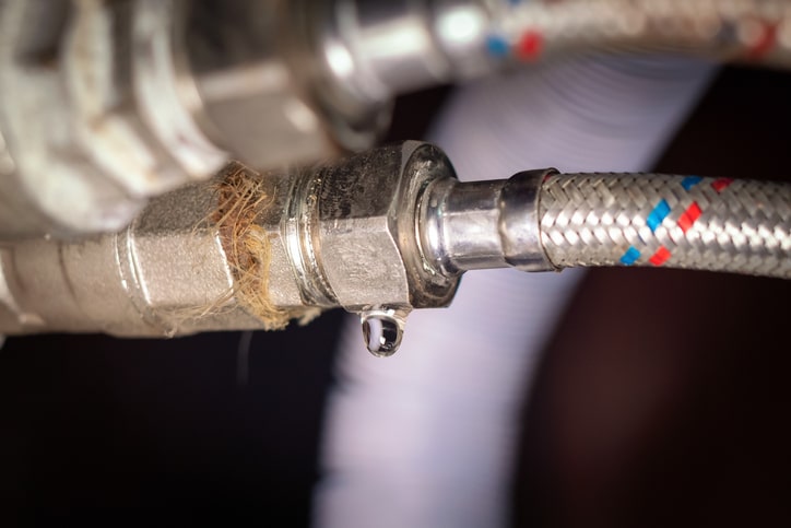 Close up of drop of water on old used plumbing hose.